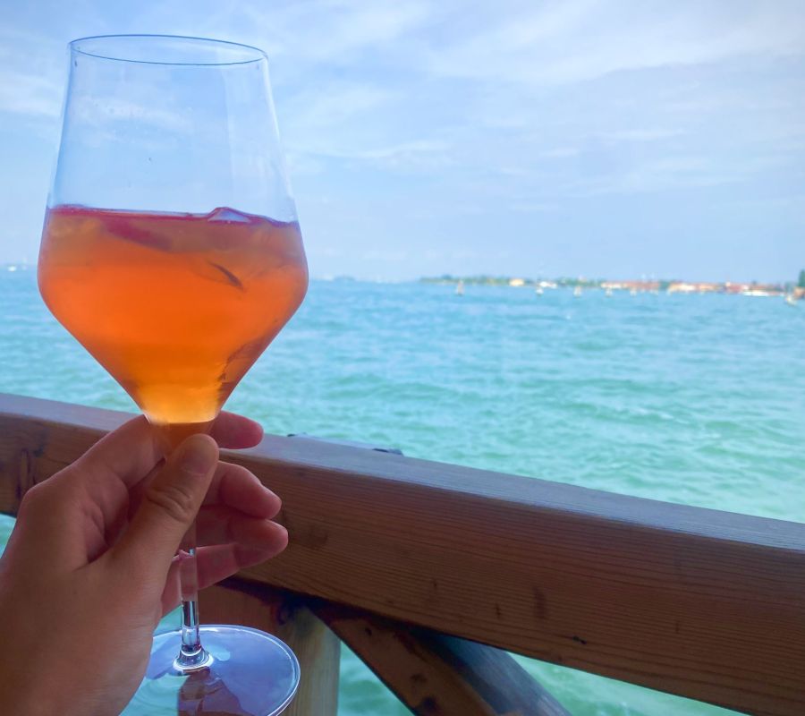 Woman Holding A Spritz On The Waterway in Venice